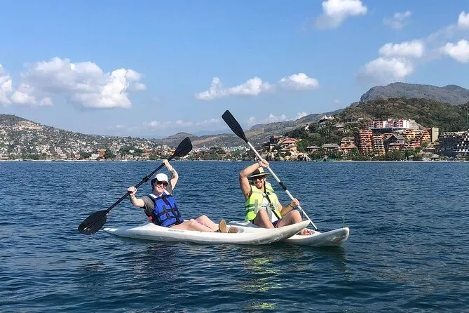 Kayakers paddling across Zihuatanejo Bay toward Las Gatas Beach on a guided kayaking and snorkeling tour in Zihuatanejo Mexico